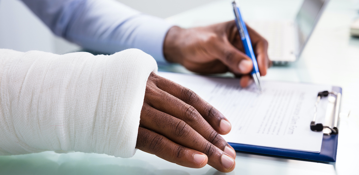 photo of an injured worker filling out a Workers' Compensation claim